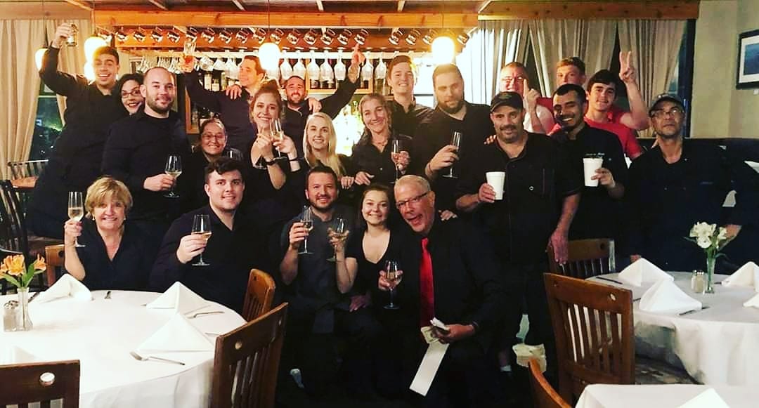 A group of restaurant employees wearing black